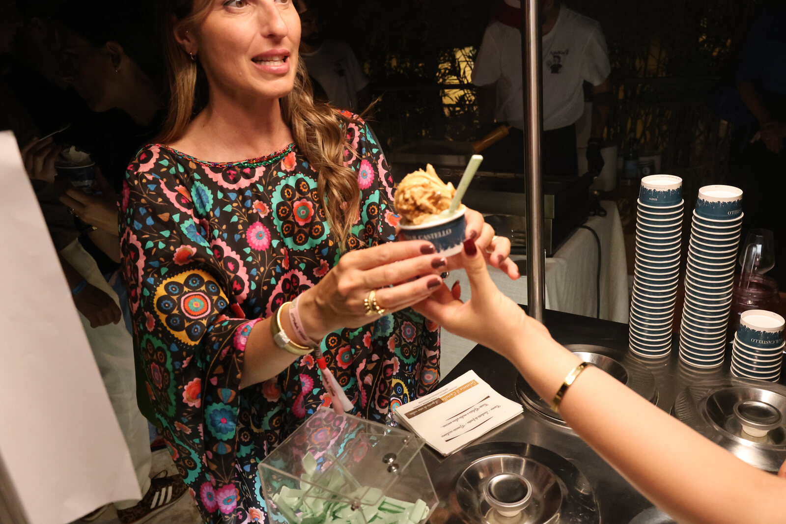 Coppetta di gelato passata di mano durante un evento